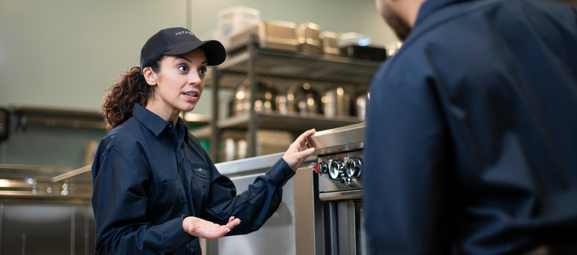 Total Tech technician talking through a repair with a colleague in a commercial kitchen
